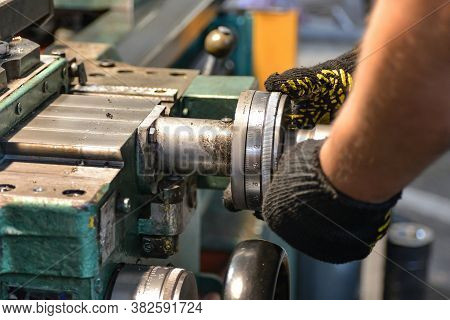 The Worker Adjusts The Accuracy Of The Cutting Feed On The Machine On The Right