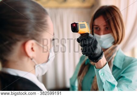 The Manager Of A Restaurant Or Hotel Checks The Body Temperature Of The Staff With A Thermal Imaging