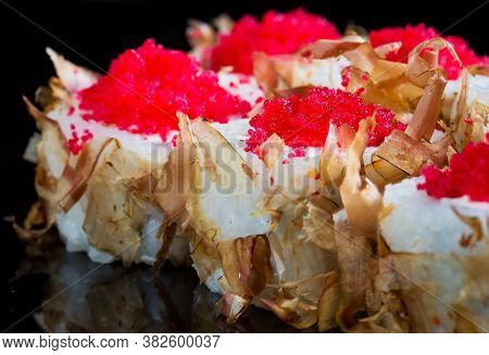 Sushi Rolls With Tuna Or Salmon Shavings On A Black Background.