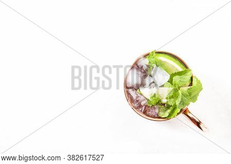 Mint Julep Or Moscow Mule Cocktail In Copper Mug With Lime, Ginger Beer, Vodka And Mint. White Table