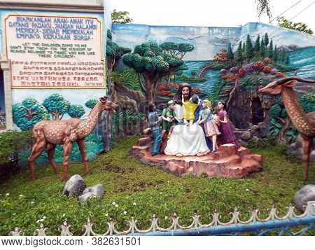 Medan, Sumatra, Indonesia, January 9, 2018: Sculpture Of Jesus Surrounded By Children And An Animal 