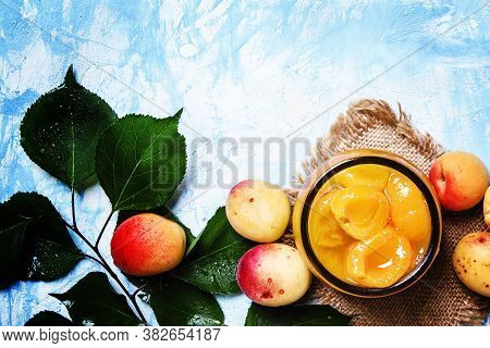 Apricot Jam In Glass Jar And Fresh Apricots With Leaves, Top View