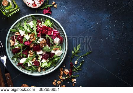 Arugula, Beet And Cheese Salad With Fresh Radicchio And Walnuts On Plate With Fork, Dressing And Spi
