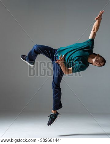 Cool Young Guy Breakdancer Jumps Dancing Hip-hop Isolated On Gray Background. Dance School Poster. B