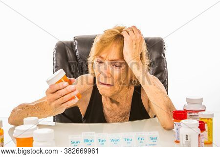 Senior Woman Wondering About Pills She Is Adding To Her Weekly Pill Box