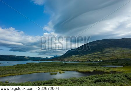 Swedish Lapland landscape. Lake Alisjavri on Kungsleden and Nordkalottruta Arctic hiking Trail in northern Sweden. Arctic environment of Scandinavia in summer day with unusual cloud formation