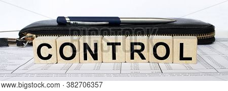A Word Control Written In A Wooden Cube With A Pen And Wallet