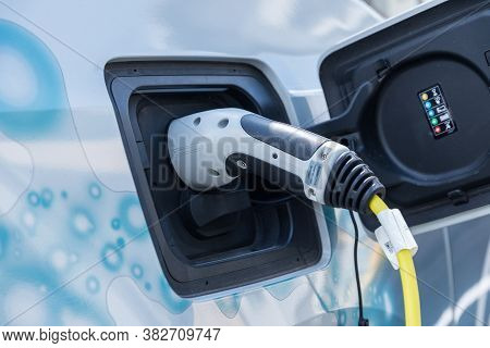 Electric Car Charging - Electric Car Plugged In At The Charging Station
