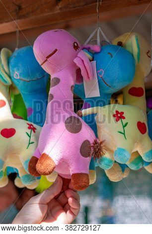 Multi-colored Soft Toy Giraffe Hang  The Souvenir Counter.  The Pink One Is In The Center.  The Sun 