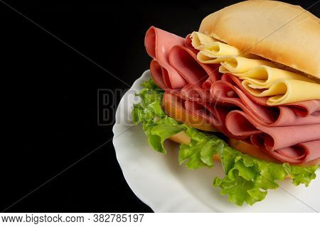 Mortadella Sandwich, Lettuce And Cheese On A White Plate On A Table With Black Tablecloth, Selective