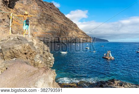 A Young Tourist In Summer From The Viewpoint Looking And Enjoying The Cove Of Puerto De Puntagorda, 