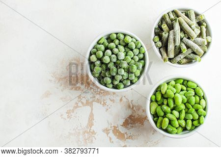 Frozen Vegetables Green Peas, Soy, Green Beans, And Baby Food In White Bowls With Copy Space. Health