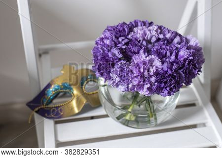 Bridal Bouquet Of Lilac Carnations In A Round Glass Vase As Decoration In White Interior