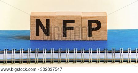 Wooden Blocks With The Word Nfp. Nonfarm Payrolls - Key Economic Indicator. Natural Family Planning 