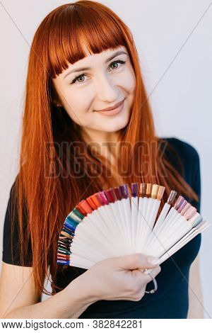 Girl With A Beautiful Manicure, Holding In Her Hands Samples Of Manicure. Portrait Of A Woman With R
