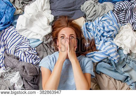 Beautiful Caucasian Woman Smiling And Lying Down With Clutter Clothes On The Floor.