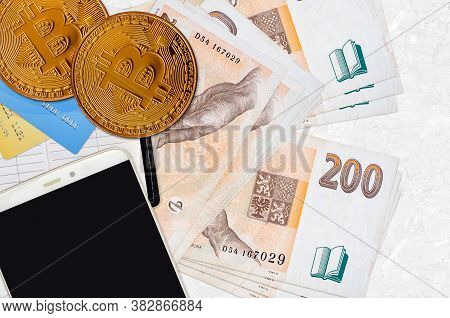 200 Czech Korun Bills And Golden Bitcoins With Smartphone And Credit Cards. Cryptocurrency Investmen