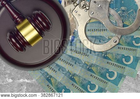 5 Canadian Dollars Bills And Judge Hammer With Police Handcuffs On Court Desk. Concept Of Judicial T