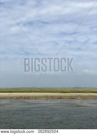 Unrecognizable people, tourist walking on the beach at Saint-Valery-sur-Somme