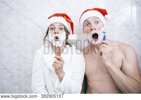 Young Happy Couple Near With Santa Hats. Beautiful Christmas Couple In Santa Hats. Bathroom. Smile W