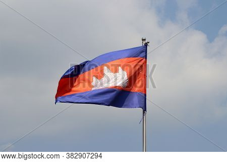 National Flag Of Cambodia On Bright Blue Sky Background. Blown Away By Wind. Cambodia Is One Of The 