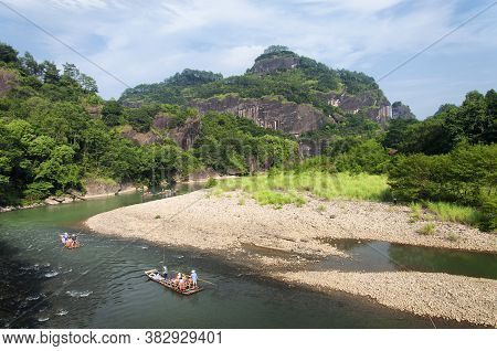 Bamboo Rafts Traveling Down Nine Bend River In Wuyishan, Fujian Province China On A Hazy Summer Day.