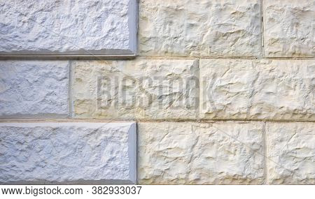 White And Yellow Rough Tiles On The Walls. Background Texture