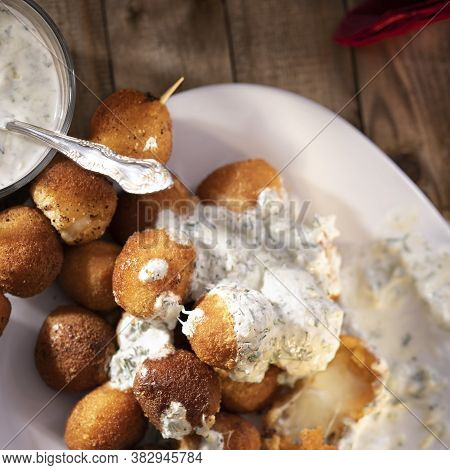 Round Fried Mozzarella Cheese Sticks Under Tzatziki Sauce From Yogurt With Cucumbers And Garlicon Wo