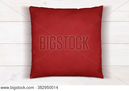 Top Down View Of Square Red Throw Pillow Sitting On A White Wood Background
