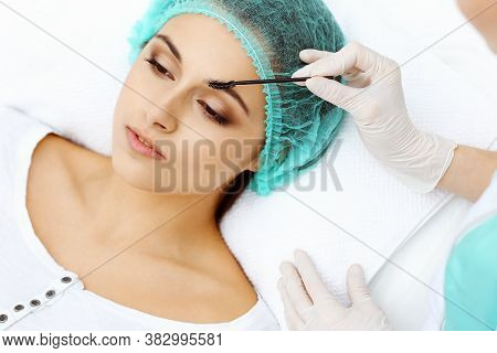 Professional Beautician Is Doing Cosmetic Procedure At Light Medical Background Touching Patients Fa