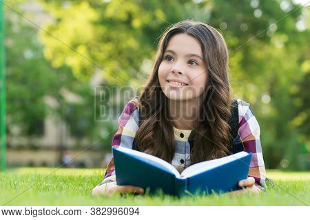 Reading Helps Your Seed Of Knowledge Grow. Happy Kid Read Book Lying On Green Grass. Knowledge Day. 