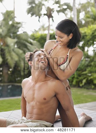 Szczęśliwy pół ubrany młoda para relaksujący w ogrodzie