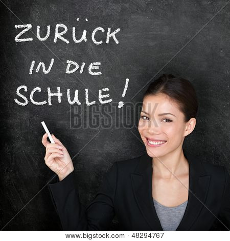 Zuruck in die Schule - femme professeur d'allemand. Retour à l'école, écrit en allemand sur tableau noir par femal