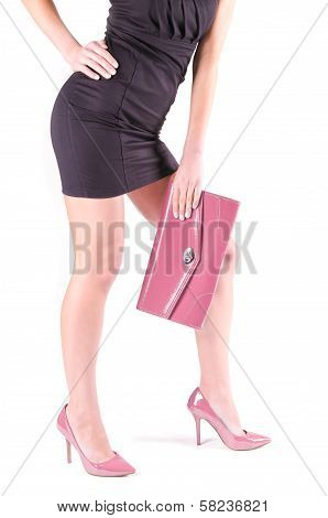 Female legs in pink shoes and mini bag