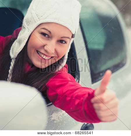 Smiling young pretty woman in the car - safe winter driving concept