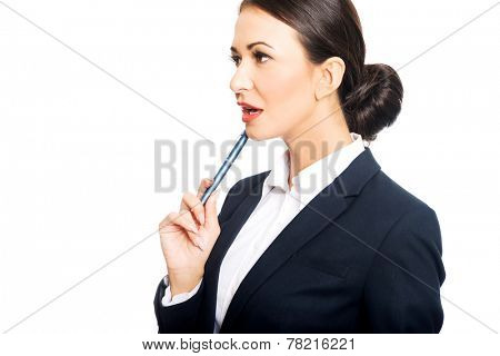 Portrait of businesswoman holding pen under chin.
