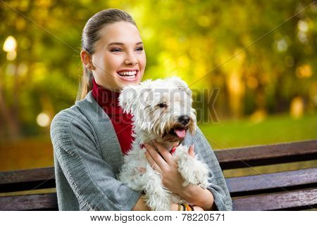 Young  girl hugging  her dog in park 