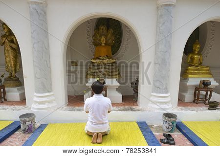 Man prays in front of the Buddha statue in Nakhom Pathom, Thailand.