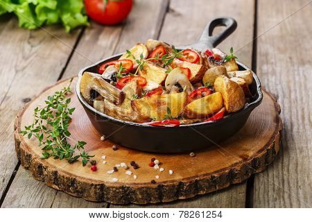 Fried potatoes with mushrooms in a frying pan