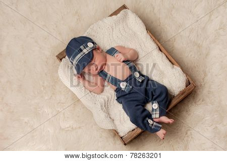 Newborn Baby Boy Wearing A Hat And Suspenders