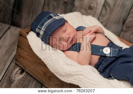 Newborn Baby Boy Wearing A Newsboy Cap And Suspenders