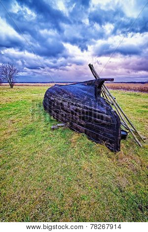 Overthrown Fisherman Boat On The Lake Shore At Stormy Weather