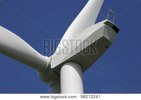 White wind turbine against dark blue sky
