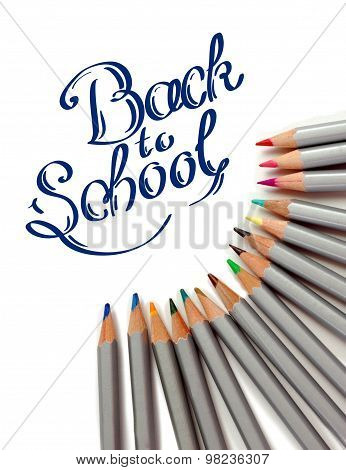 Sharpened monochrome watercolor pencils with multicolor slate-pencil on a white background and hand