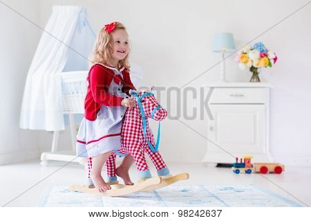 Little Girl Riding A Toy Horse