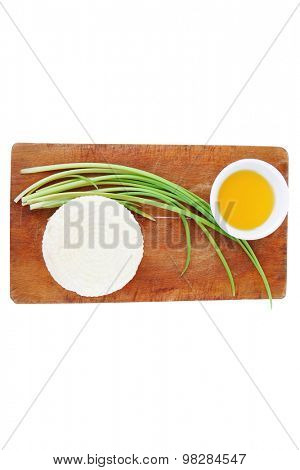 dairy products : feta white cheese on cut board with olive oil in small saucer isolated over white background