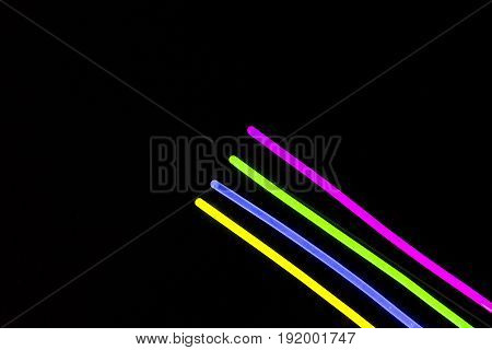 Glow sticks neon light fluorescent on back background. variation of different colored chem lights