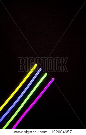 Glow sticks neon light fluorescent on back background. variation of different colored chem lights