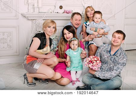 Three Generation Family Sitting On Sofa Together. Classic Portrait
