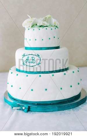 A multi-level white maroon wedding cake with white lilies on top